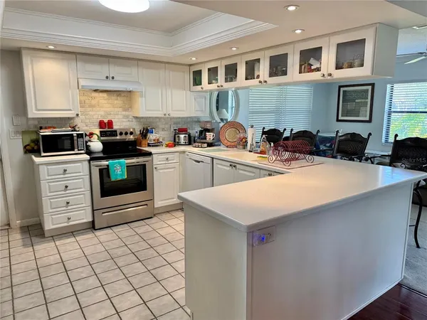 a kitchen with stainless steel appliances a stove a sink a microwave and cabinets