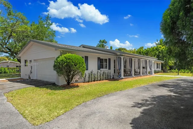 a view of a house with backyard and sitting area