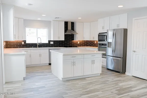 a kitchen with white cabinets stainless steel appliances and a sink