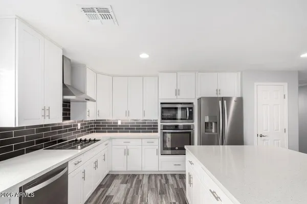 a kitchen with refrigerator a sink and white cabinets