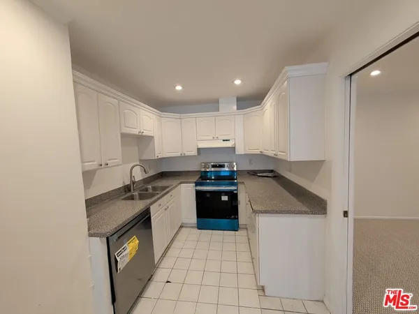 a kitchen with a stove sink and cabinets