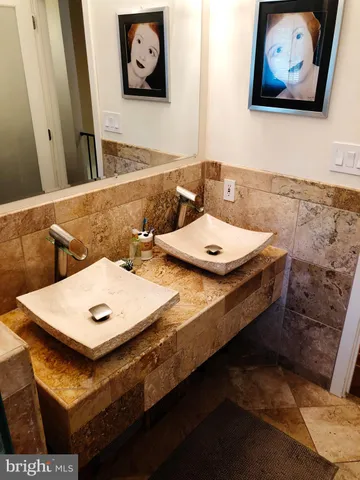 a bathroom with a granite countertop sink a toilet a mirror and shower