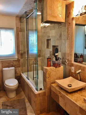 a bedroom with 2 bed table chair and a window