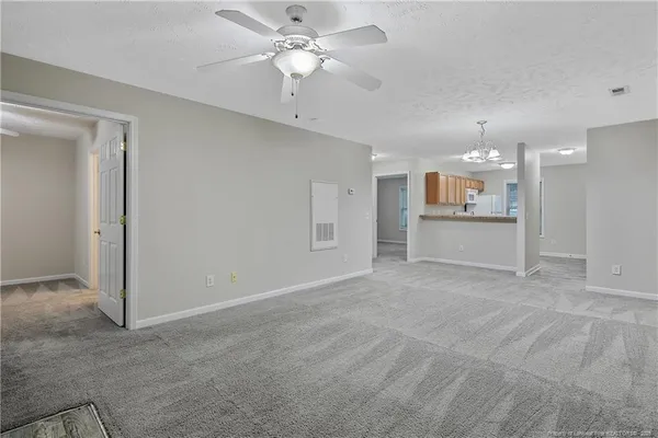 an empty room with a kitchen and a ceiling fan window