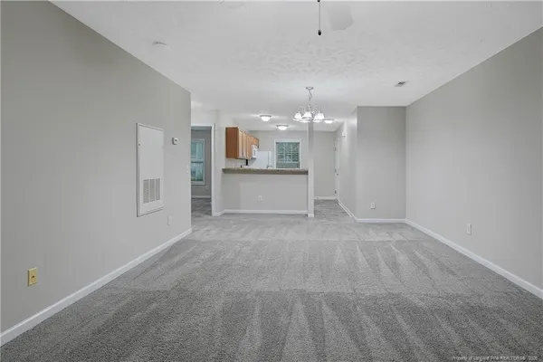an empty room with a kitchen and a ceiling fan window