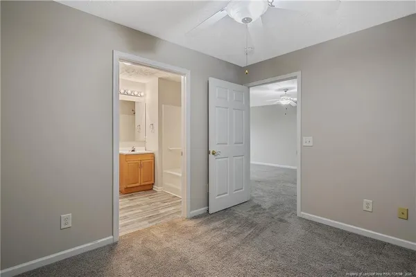 an empty room with a ceiling fan and a window