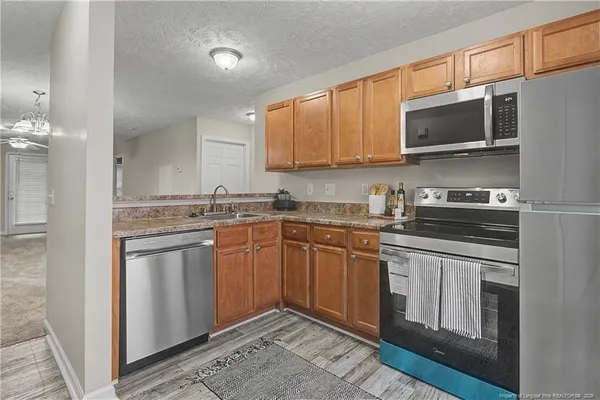 a kitchen with stainless steel appliances granite countertop a stove a sink and a microwave