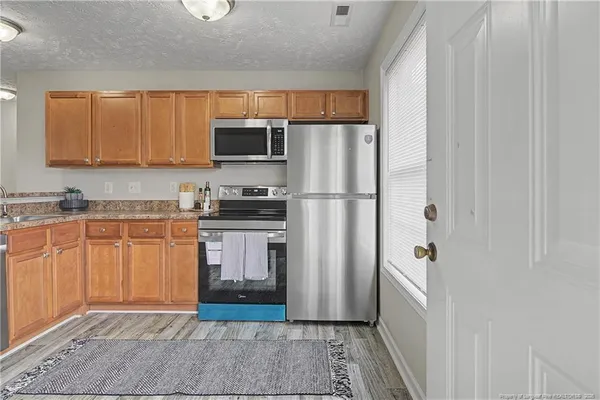 a kitchen with stainless steel appliances granite countertop a refrigerator and a stove top oven