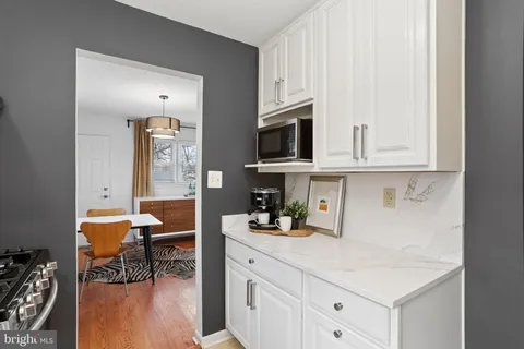 a kitchen with stainless steel appliances white cabinets and wooden floor