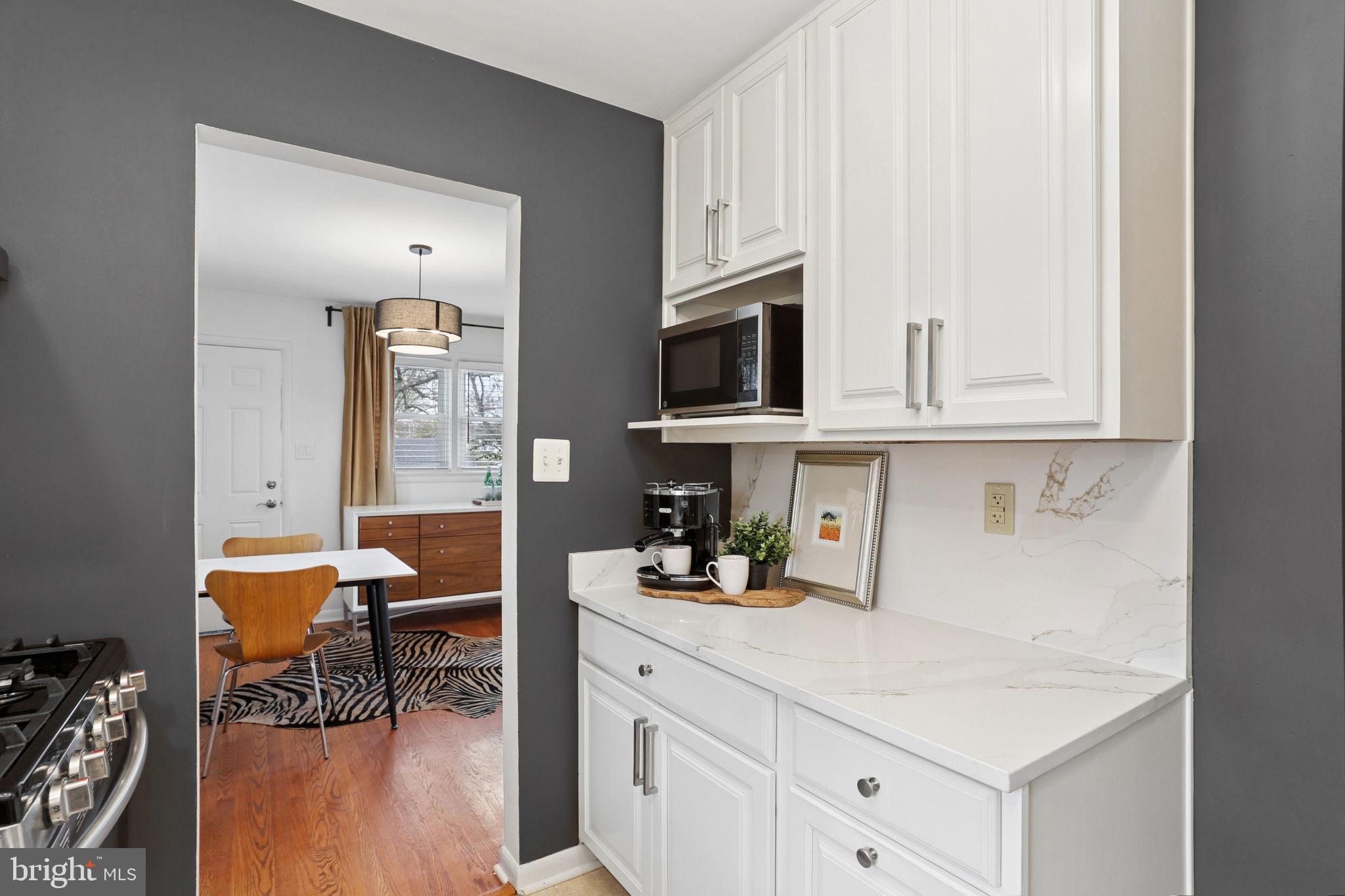 5909 Ridge View Drive Alexandria, VA 22310 - Photo 13 of 35 a kitchen with stainless steel appliances white cabinets and wooden floor