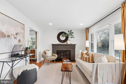 a living room with furniture a fireplace and a large window