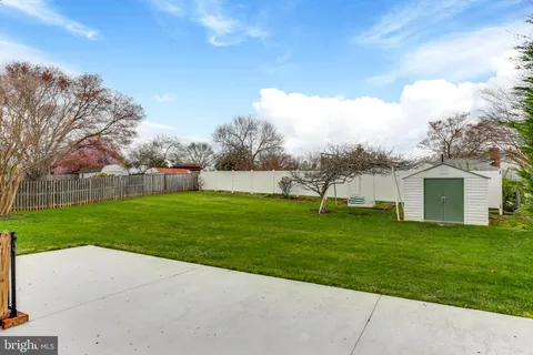 a view of a house with a big yard and large trees