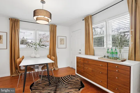 a dining room with wooden floor and a chandelier