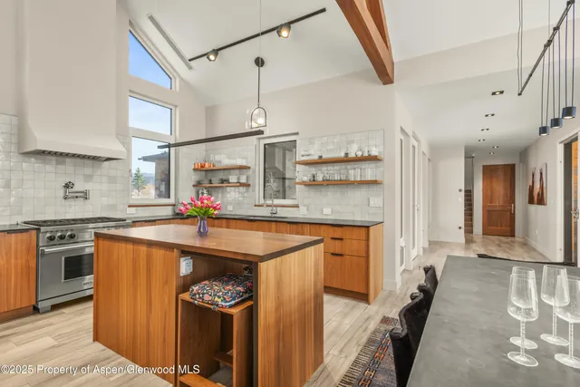 a kitchen with stainless steel appliances granite countertop a sink a stove and a refrigerator