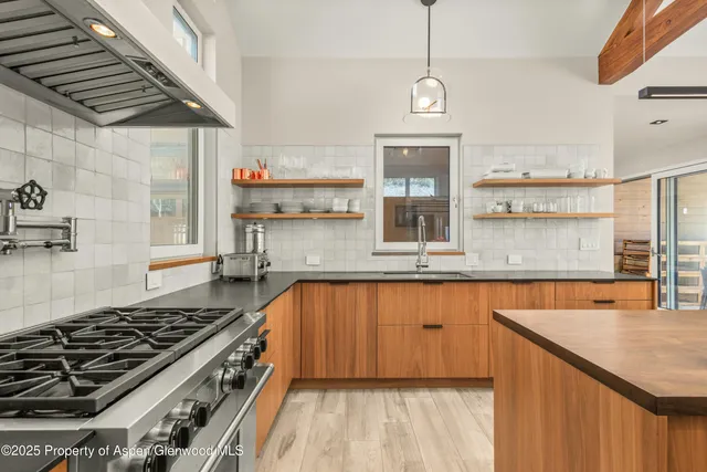 a kitchen with stainless steel appliances granite countertop a stove a sink dishwasher and cabinets with wooden floor