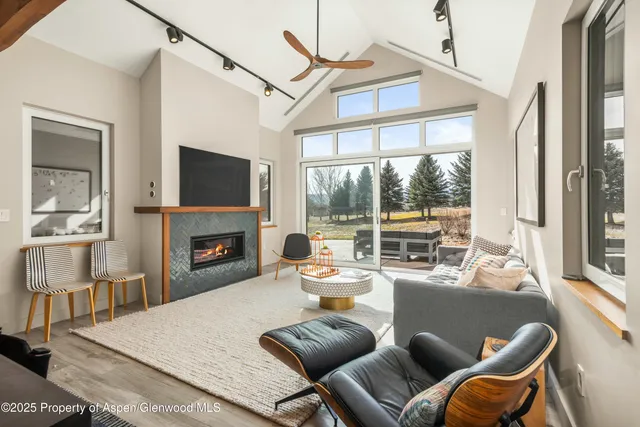 a living room with furniture a fireplace and a flat screen tv