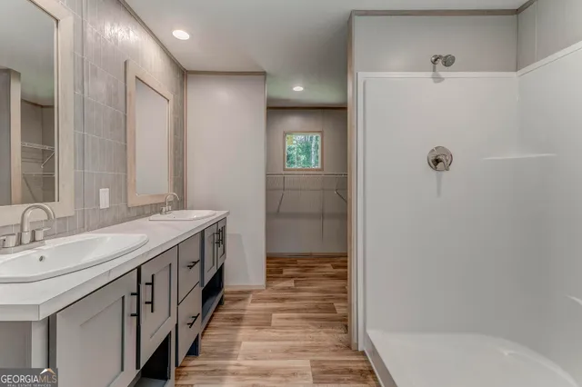 a bathroom with double vanity and a shower