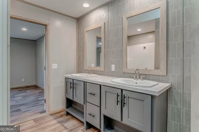 a bathroom with a granite countertop double vanity sink and a mirror