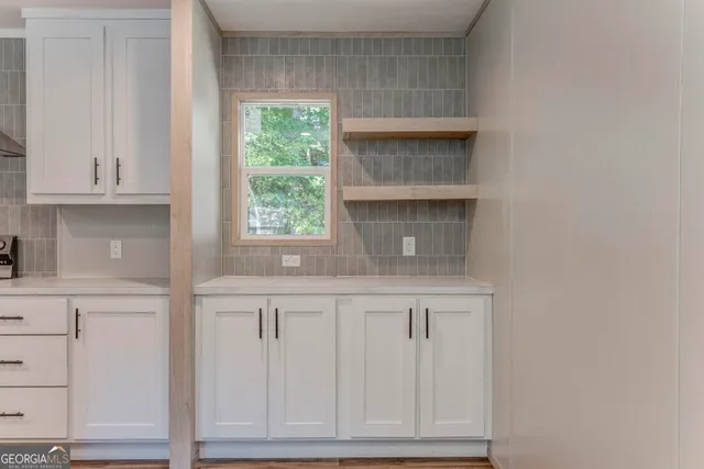 a kitchen with white cabinets and appliances