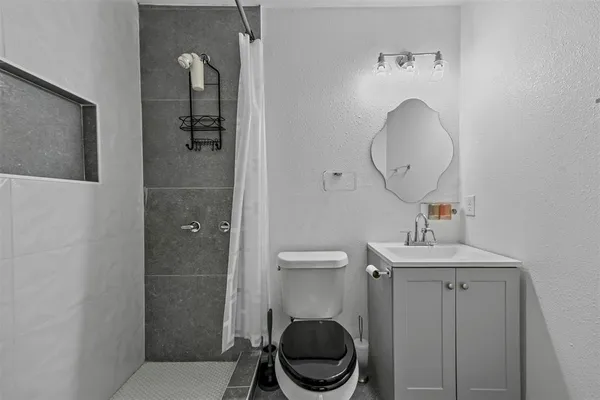 a bathroom with a toilet a sink and mirror