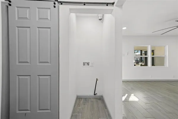 a view of a hallway with wooden floor and staircase