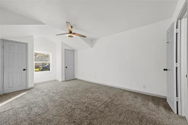 a view of an empty room with a ceiling fan