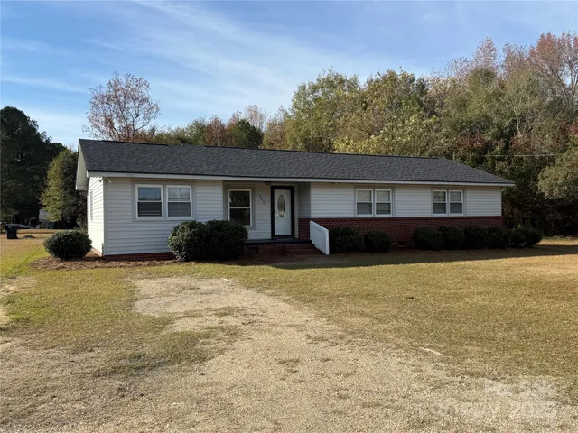 a front view of a house with a yard and trees