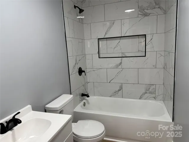 a bathroom with a sink a toilet and bathtub