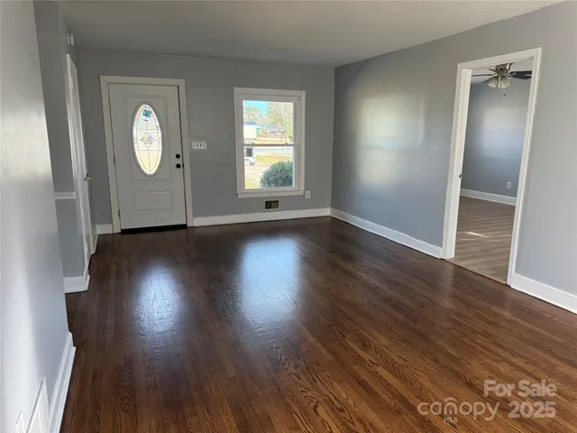 an empty room with wooden floor and a window
