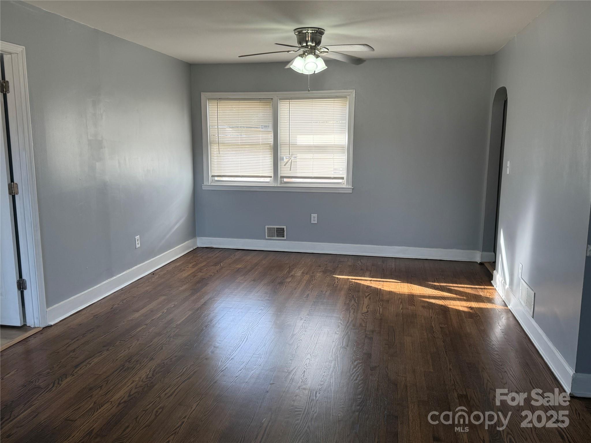 305 Tec Road Cheraw, SC 29520 - Photo 2 of 21 an empty room with wooden floor chandelier fan and windows