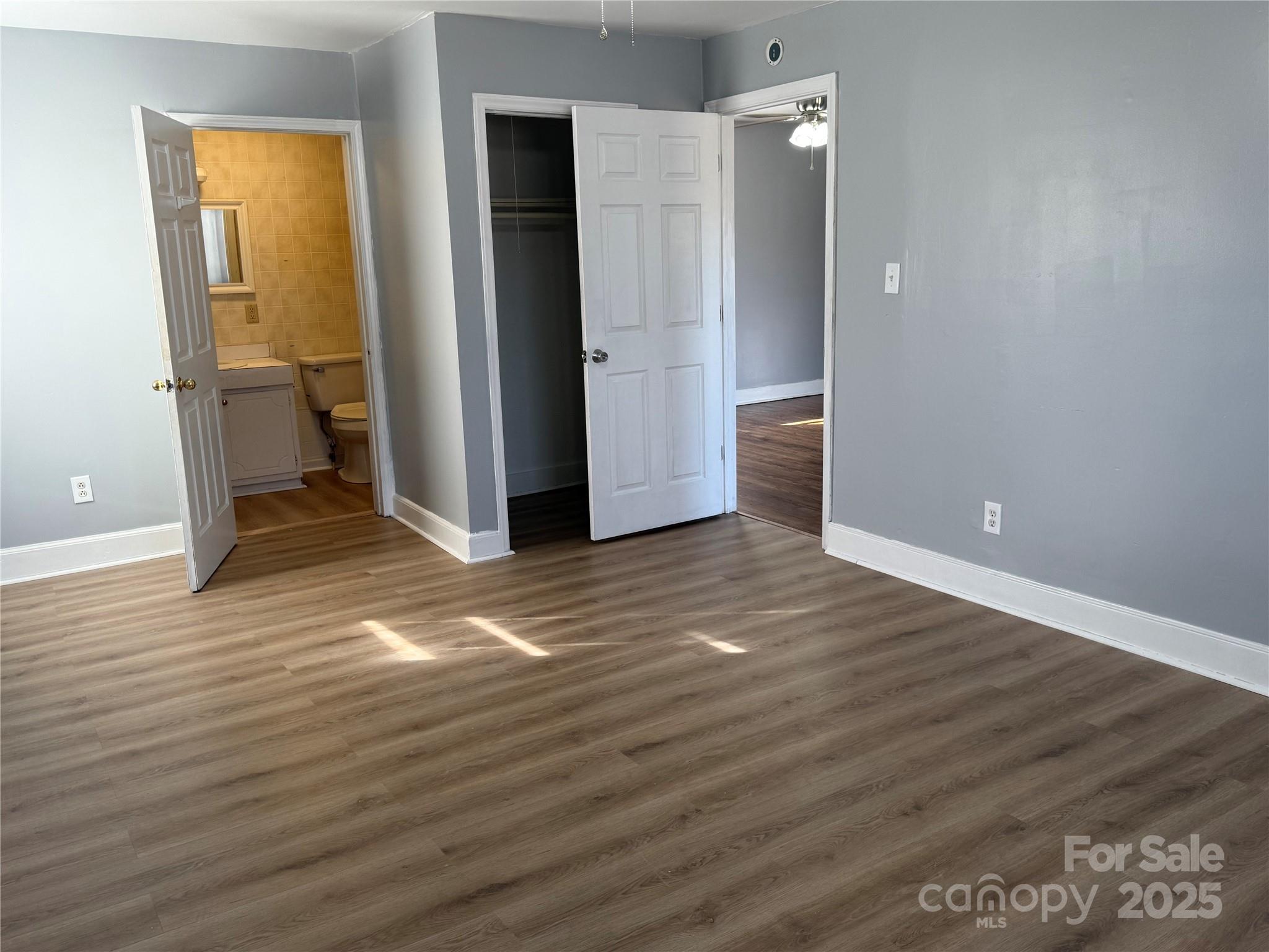 305 Tec Road Cheraw, SC 29520 - Photo 4 of 21 an empty room with wooden floor and a bathroom