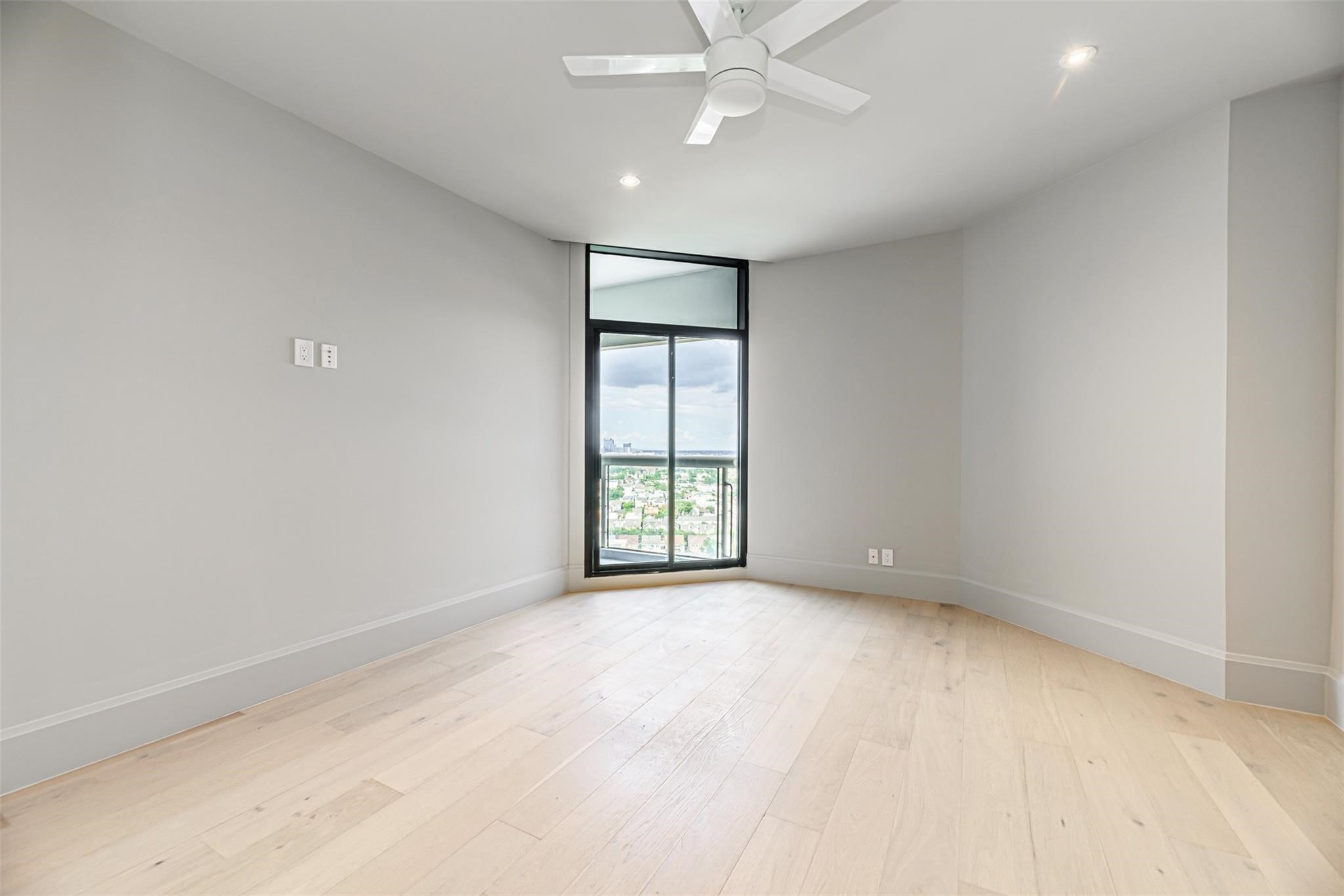 1701 Hermann Drive, Unit 22CE Houston, TX 77004 - Photo 11 of 37 wooden floor in an empty room with a window