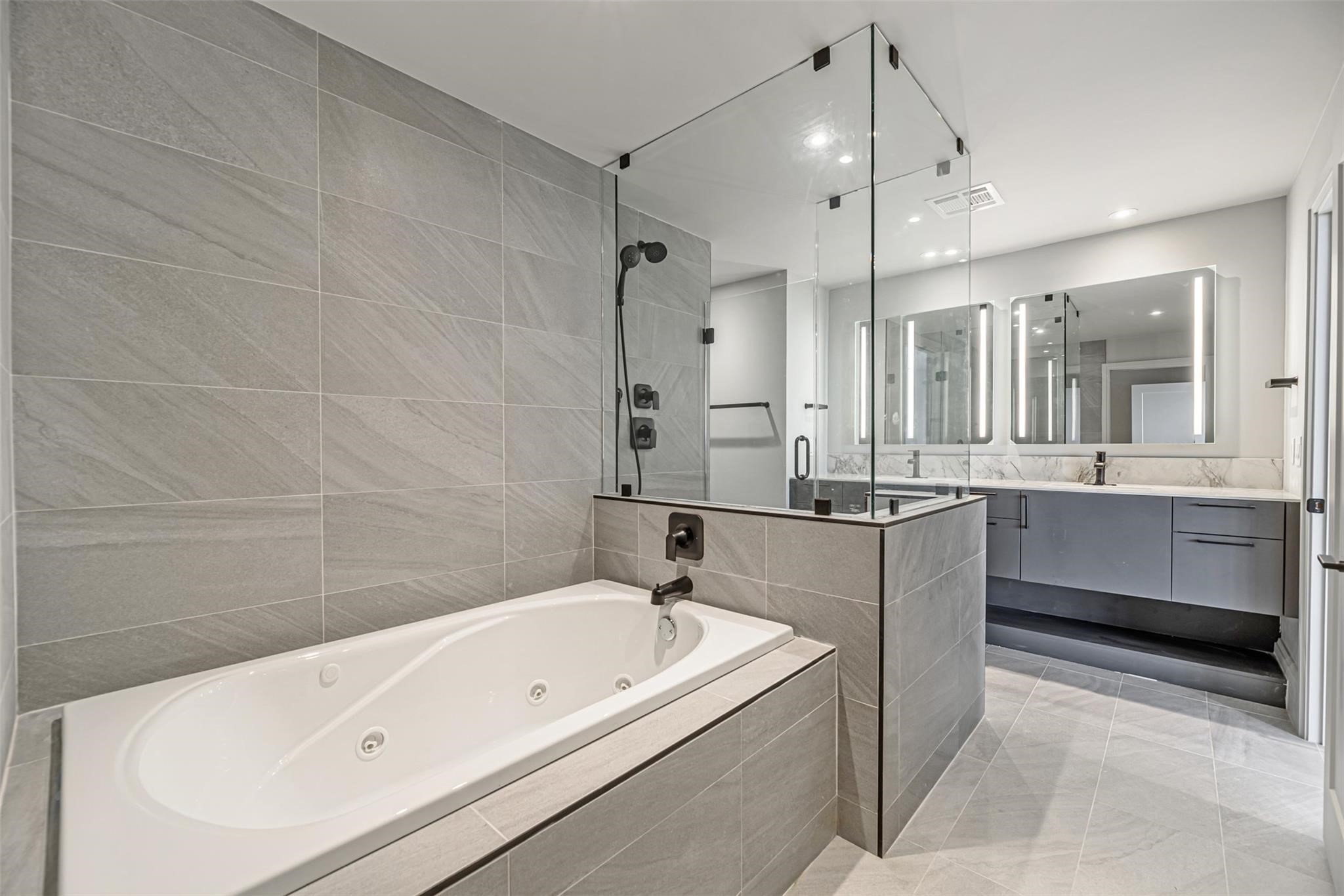 1701 Hermann Drive, Unit 22CE Houston, TX 77004 - Photo 12 of 37 a bathroom with a tub a sink shower and mirror