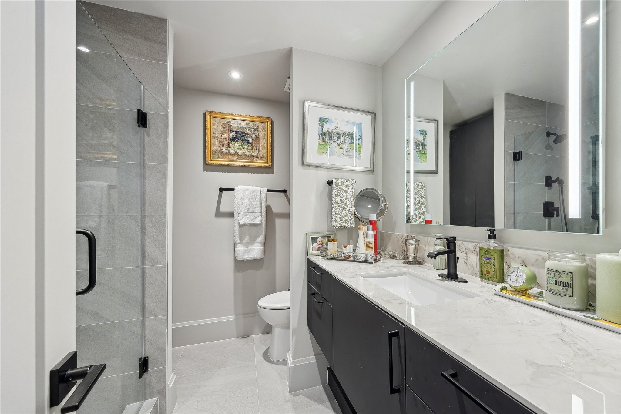 1701 Hermann Drive, Unit 22CE Houston, TX 77004 - Photo 16 of 37 a spacious bathroom with a double vanity sink toilet and shower