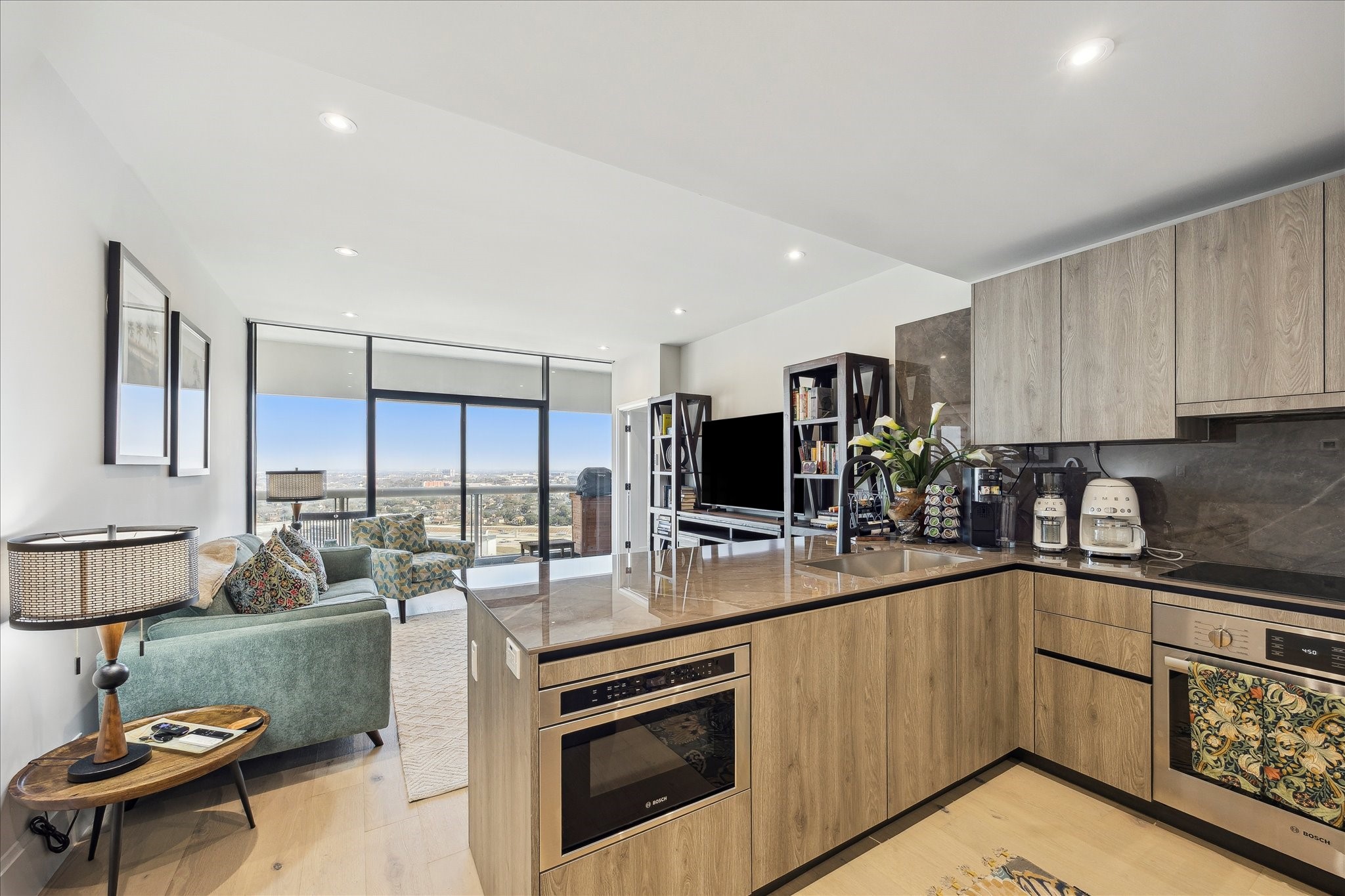 1701 Hermann Drive, Unit 22CE Houston, TX 77004 - Photo 20 of 37 a kitchen with kitchen island granite countertop a sink cabinets and stainless steel appliances