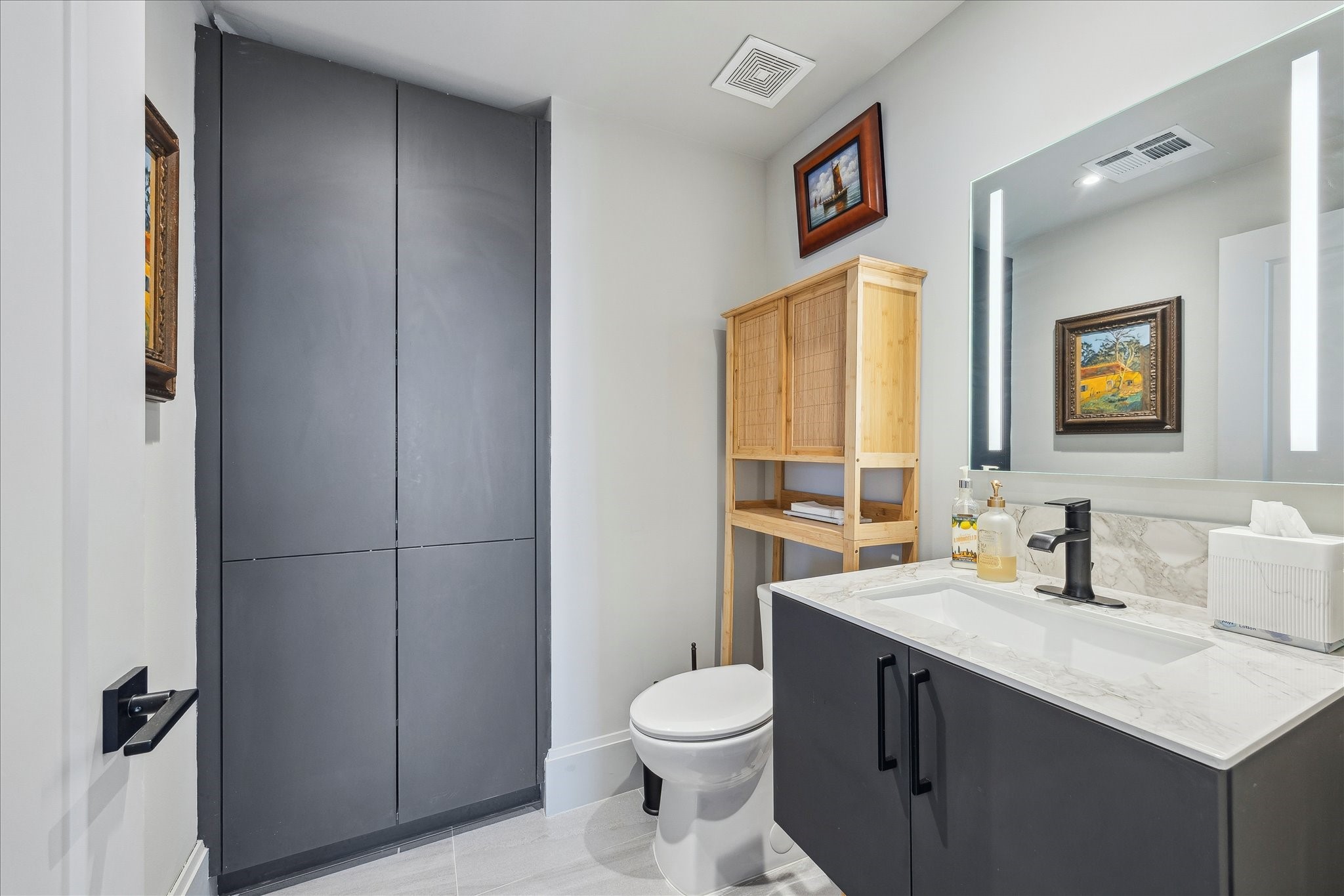 1701 Hermann Drive, Unit 22CE Houston, TX 77004 - Photo 8 of 37 a bathroom with a toilet sink vanity and mirror