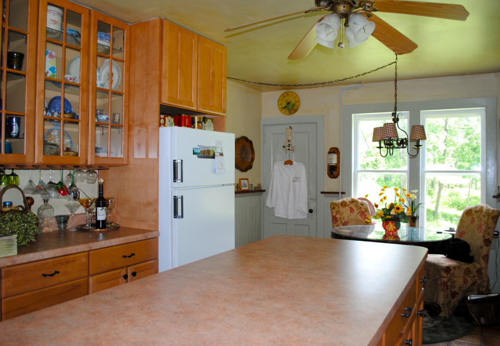 559 Main Road Monterey, MA 01245 - Photo 14 of 32 a kitchen with stainless steel appliances kitchen island granite countertop a refrigerator a sink a dining table and chairs with wooden floor