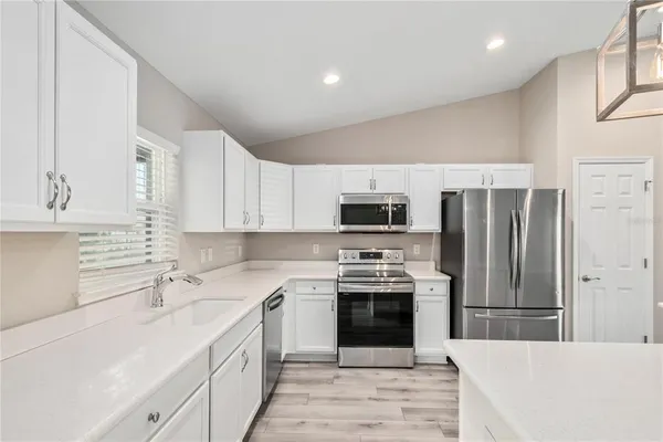 a kitchen with stainless steel appliances a stove sink microwave and cabinets