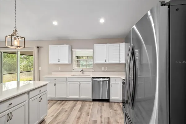 a kitchen with a sink a window and stainless steel appliances