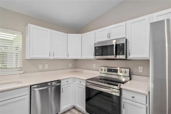 a kitchen with stainless steel appliances granite countertop a sink a stove a microwave and cabinets