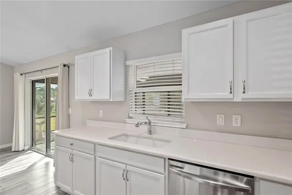a kitchen with stainless steel appliances granite countertop a sink and a white cabinets