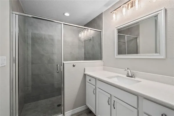 a bathroom with a shower sink and mirror