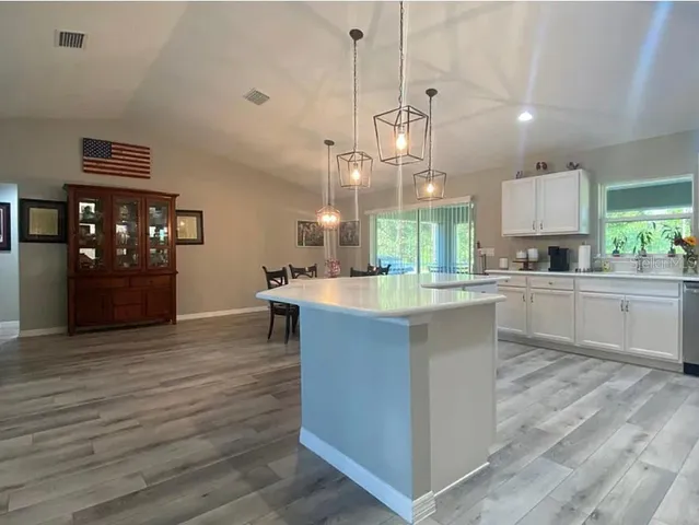 a large kitchen with kitchen island a sink stainless steel appliances and cabinets
