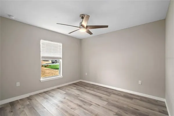 an empty room with a window and a ceiling fan