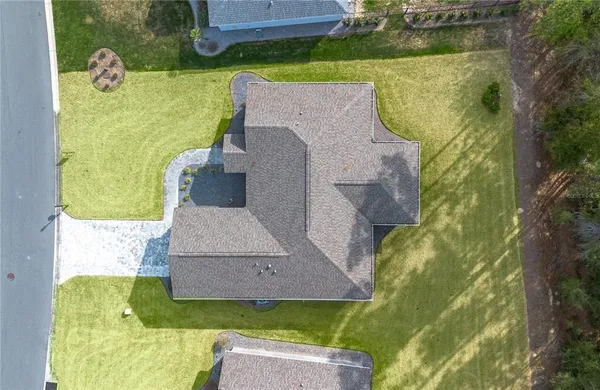 an aerial view of a house with swimming pool and a yard