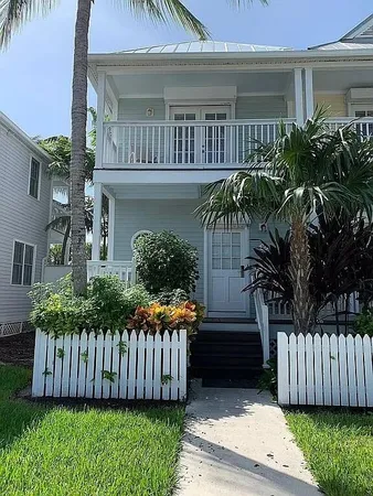 a view of a house with a yard and potted plants