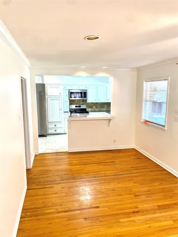 a view of a kitchen with wooden floor and electronic appliances