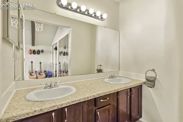 a bathroom with a granite countertop sink and a mirror