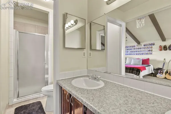 a bathroom with a granite countertop double vanity sink and a mirror