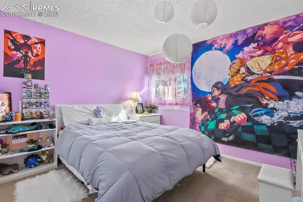 a bed room with a bed mirror and a lamp